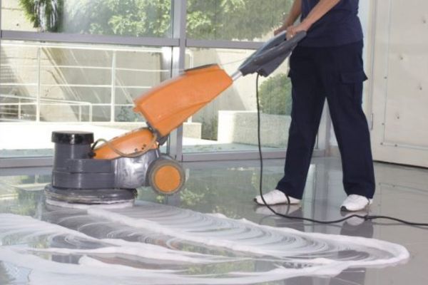 Nhân viên sử dụng dung dịch tẩy rửa chuyên dụng để làm sạch bề mặt sàn
